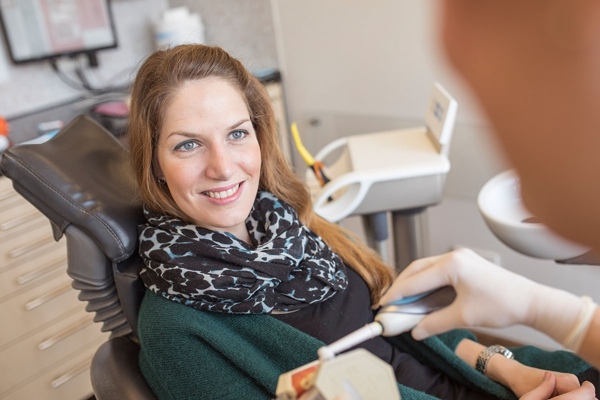 Patientin hört zu, wenn Prophylaxe Zahnarzt Hannover Zahnpflege Tipps gibt