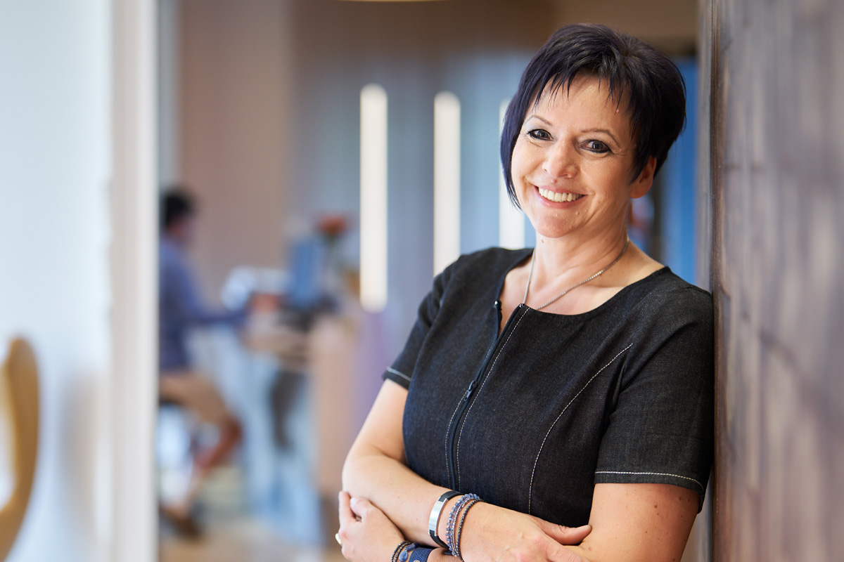 Freundliches Gesicht  nach der Behandlung: Patienten freut sich über Ihre neuen Festen Zähne in der Hannoveraner Zahnarztpraxis.