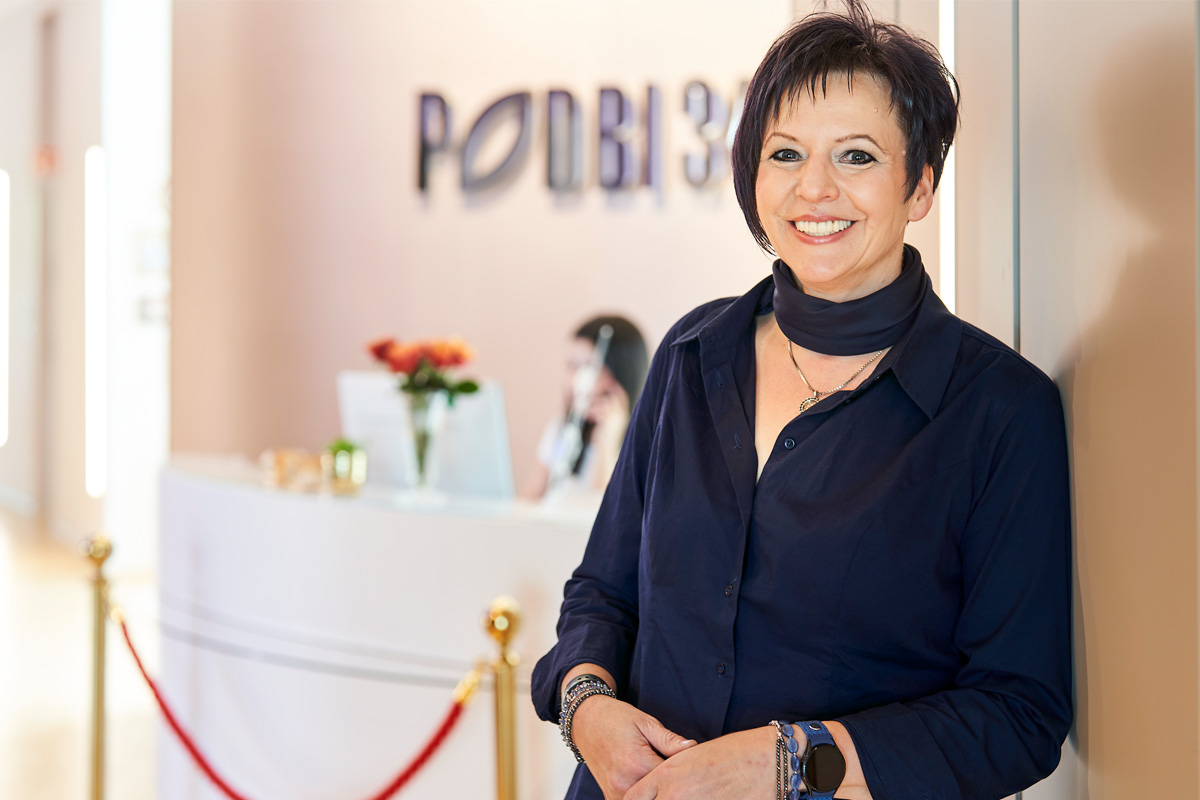 Patientin der Zahnarztpraxis Podbi344 in Hannover lächelt zufrieden.