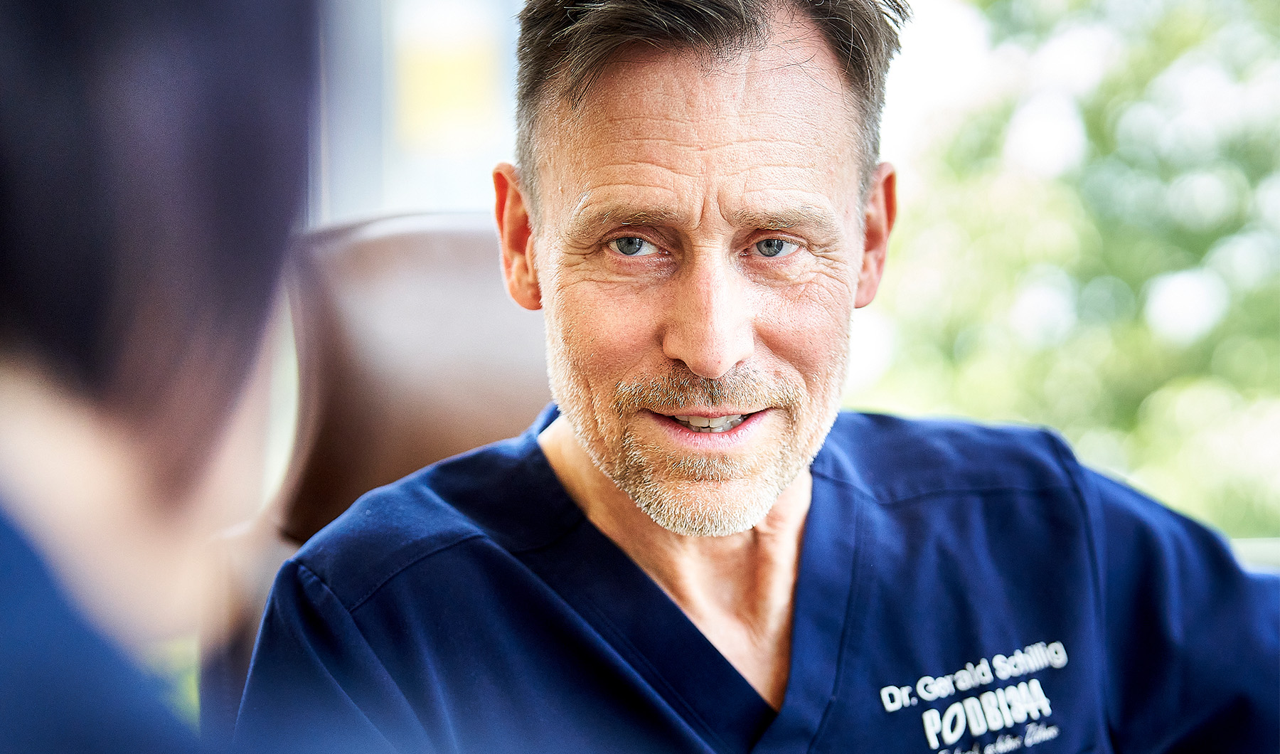 Zahnarzt Dr. Gerald Schillig von der Zahnarztpraxis Podbi344 in Hannover lächelt freundlich.