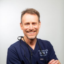 Zahnarzt Dr. Gerald Schillig von der Zahnarztpraxis Podbi344 in Hannover lächelt freundlich. Ihr Experte für Zahnmedizin und Feste Zähne freut sich auf Sie.